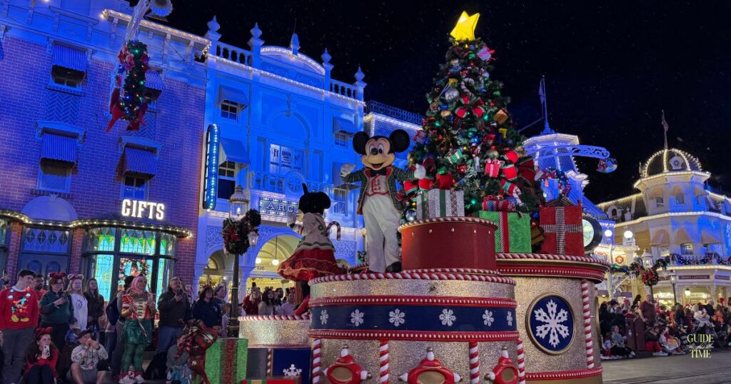 Mickey Mouse waving from a Christmas tree float in the parade at Mickey's Very Merry Christmas Party